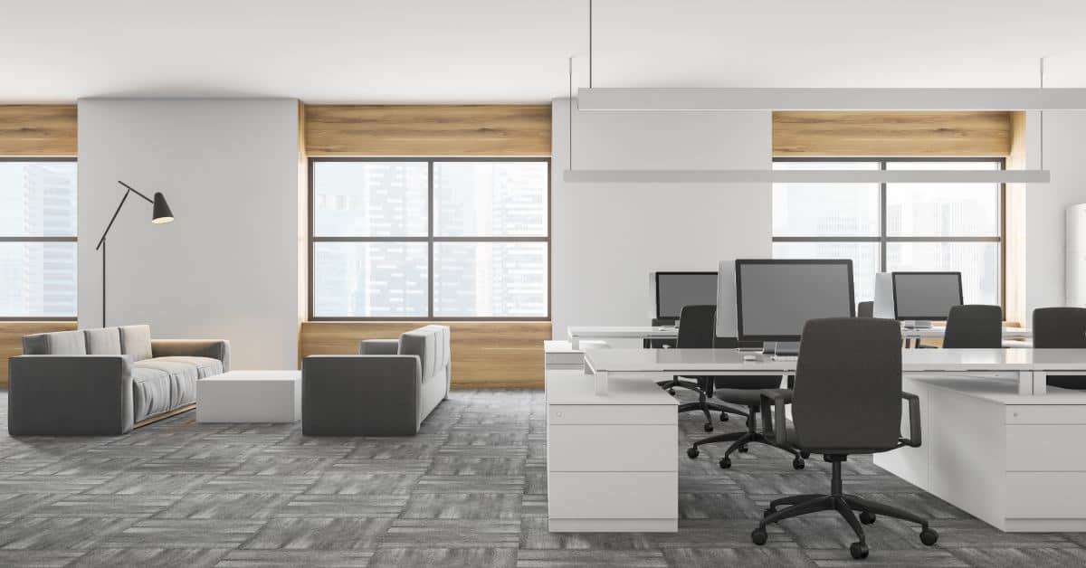 an office room with computer desks and lounge chairs